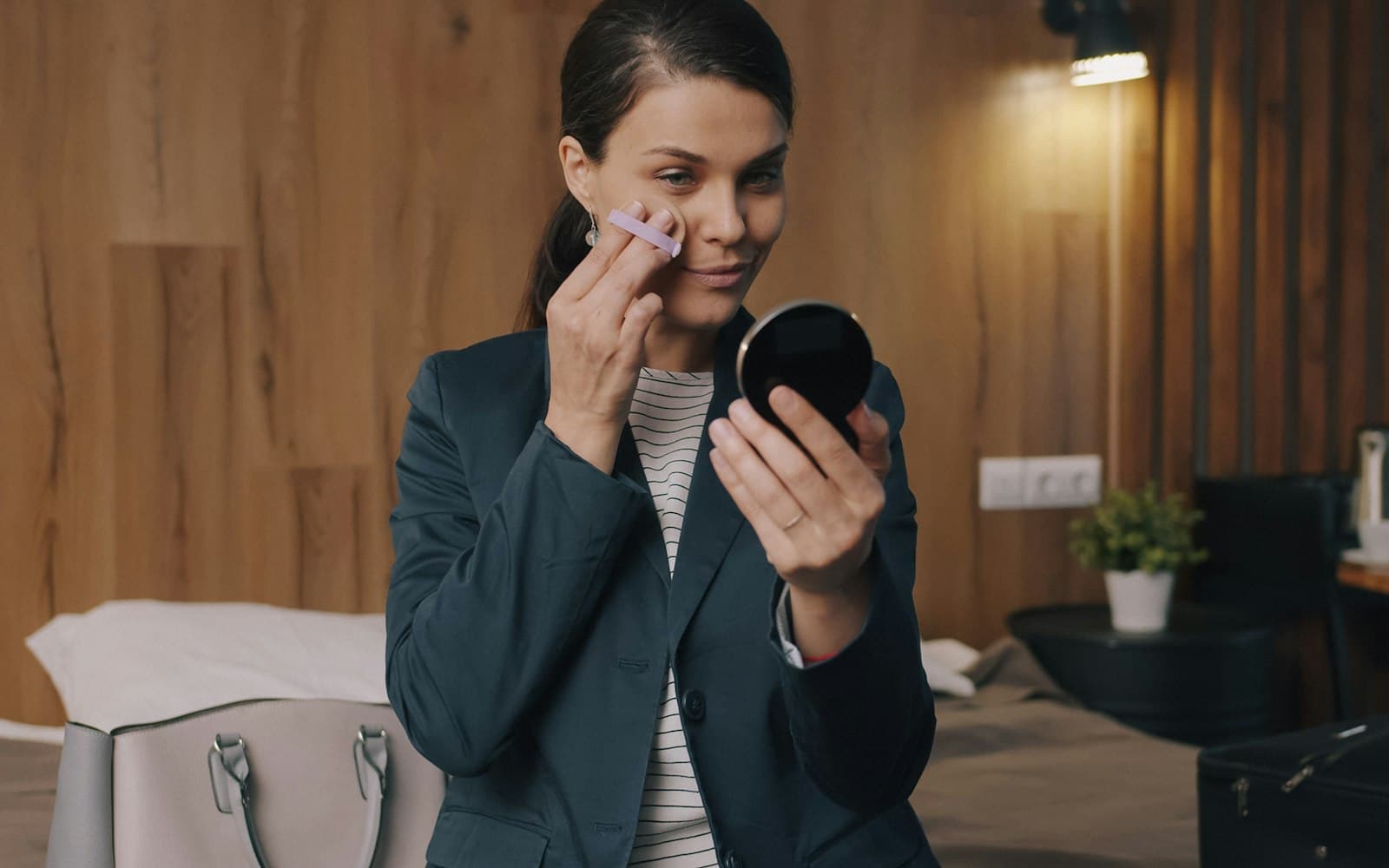 A woman looking closely at her skin in a mirror