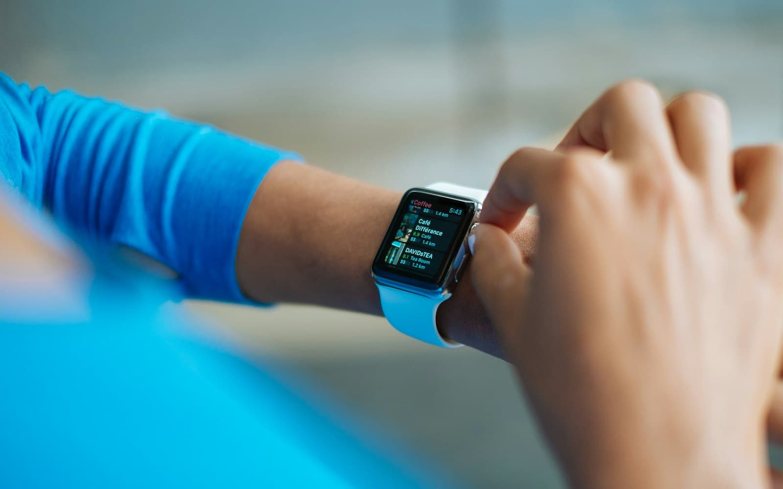 A person tapping the smartwatch on their wrist